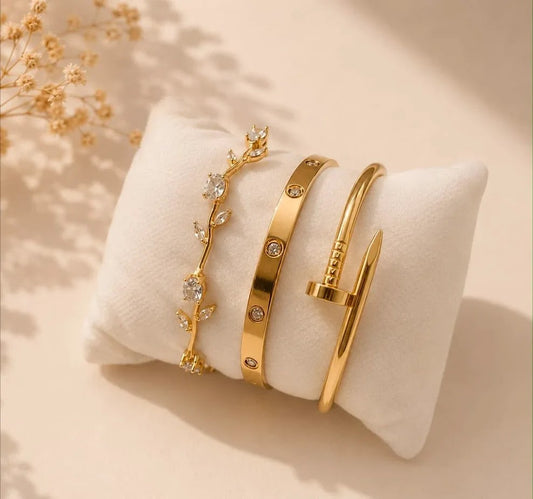 Luxury bangle stack on display pillow — Cartier Love, Nail, clear zirconia stone chain